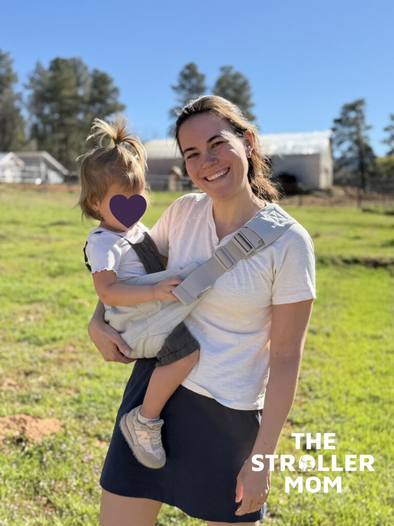 Toddler sitting in the Ergobaby Upsie Sling in hip carry position