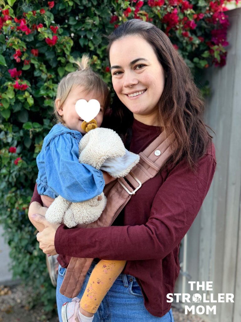 Front view of the Mabe Monarch Toddler Sling in Mocha with toddler seated on the hip