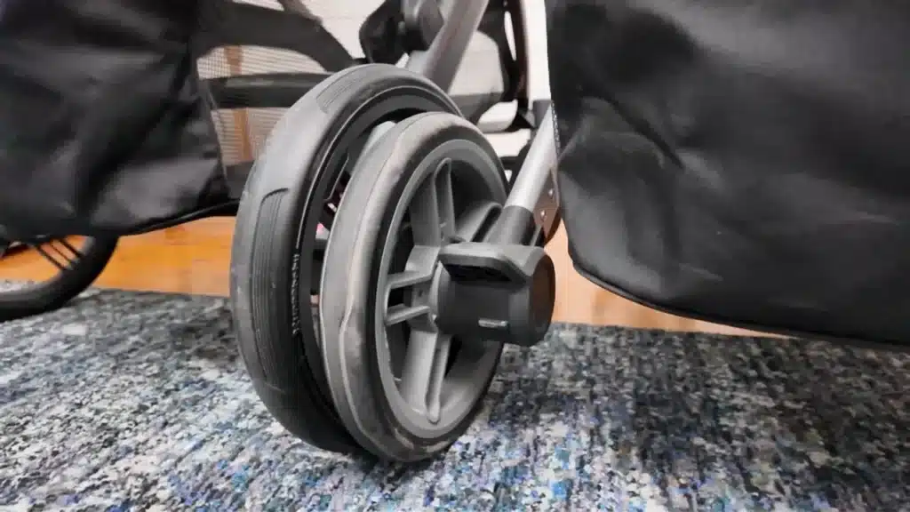 Close-up of UPPAbaby stroller rear wheel and foot brake mechanism