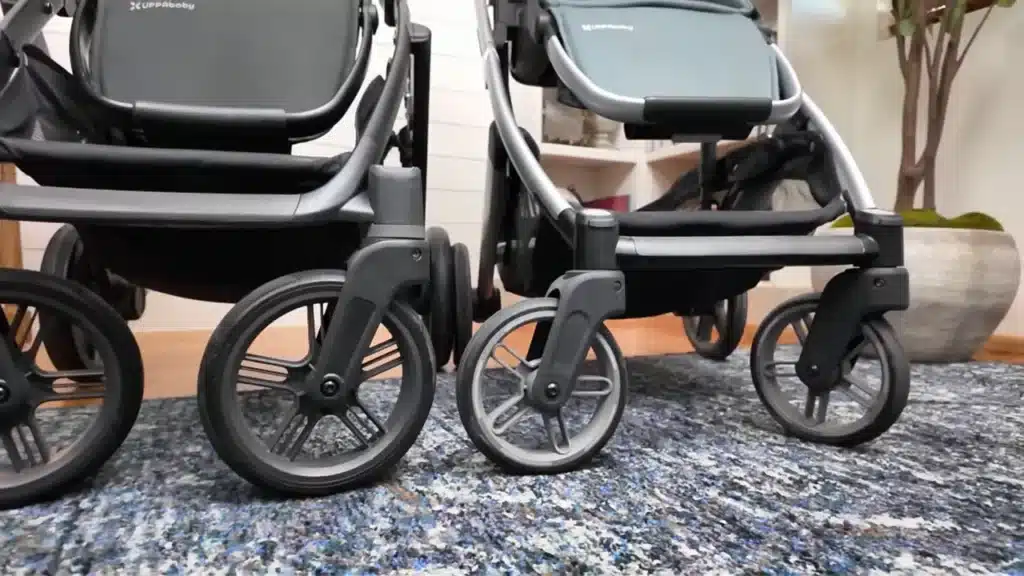 Close-up of Vista V3 and Cruz V3 rear wheels side by side showing the size difference between the two strollers