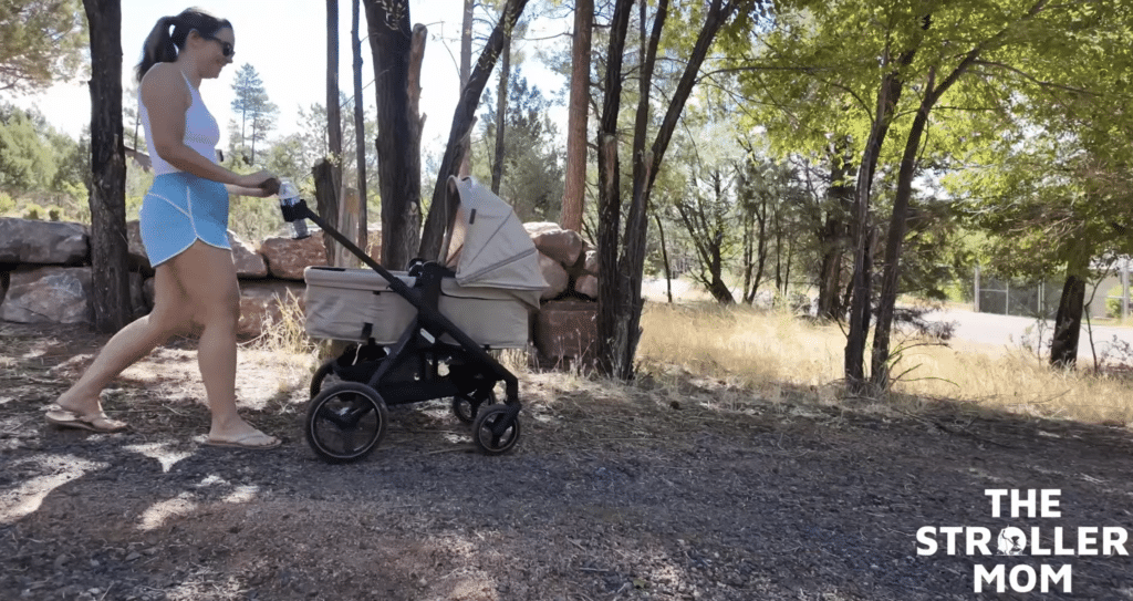 Emily pushing the Evenflo Transformer in pramette mode on a dirt path